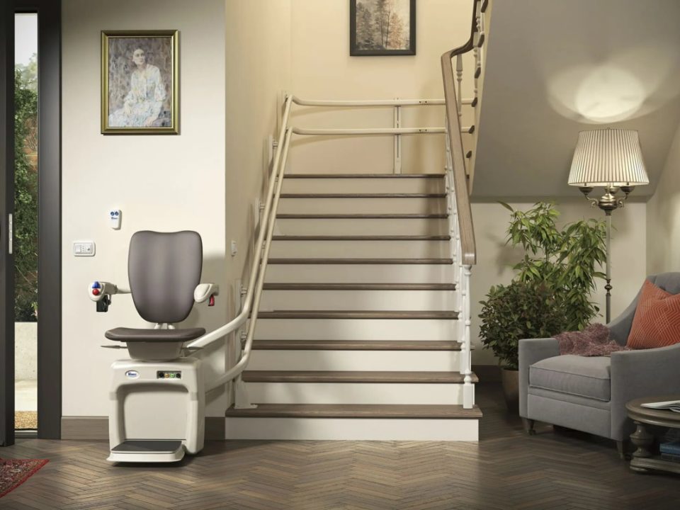 Una silla elevadora con respaldo ergonómico y mecanismo eléctrico para ajustar su altura. Diseñada para facilitar el acceso a personas con movilidad reducida, ideal para escaleras, con reposabrazos ajustables y ruedas para fácil movimiento.